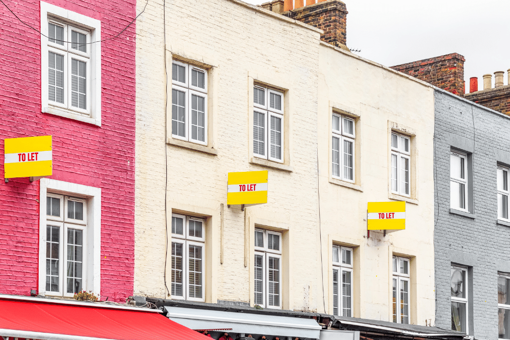 pink, cream and grey terraced houses with to let signs in front