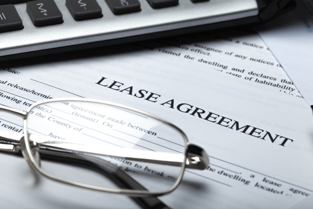 glasses and a calculator on a lease agreement form