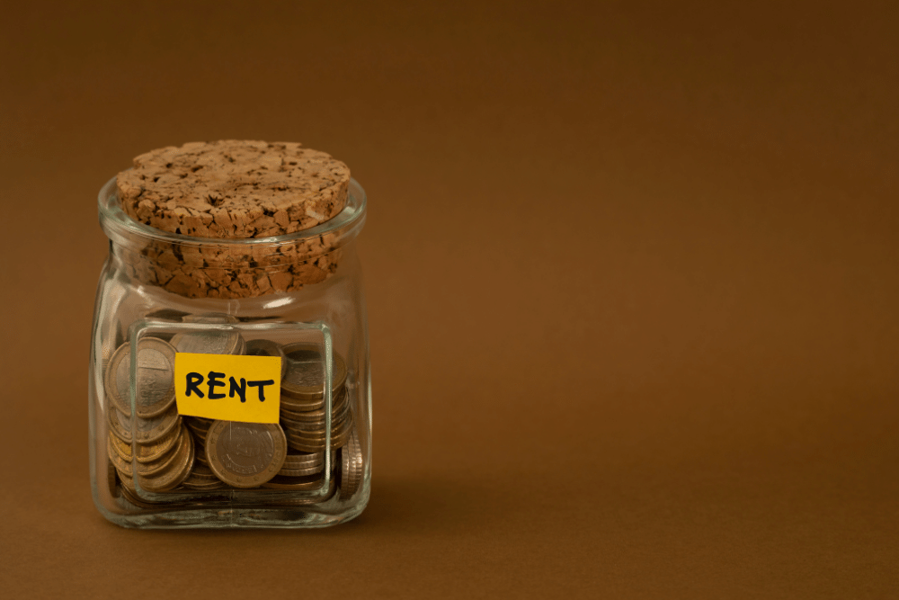 coins in a jar that says rent