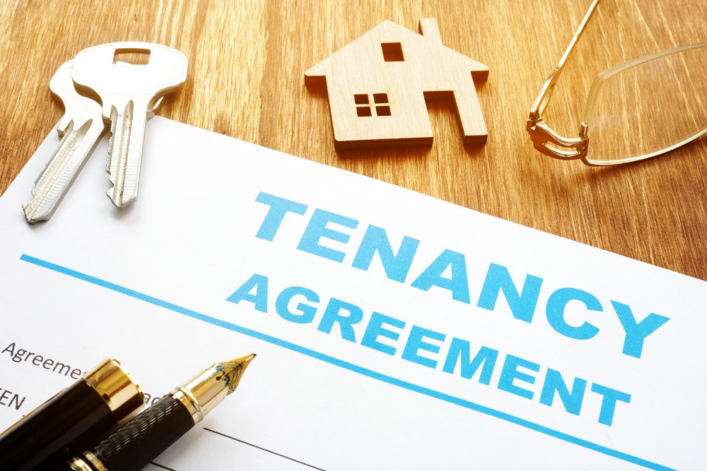 a tenancy agreement on a table with a pen and keys on top