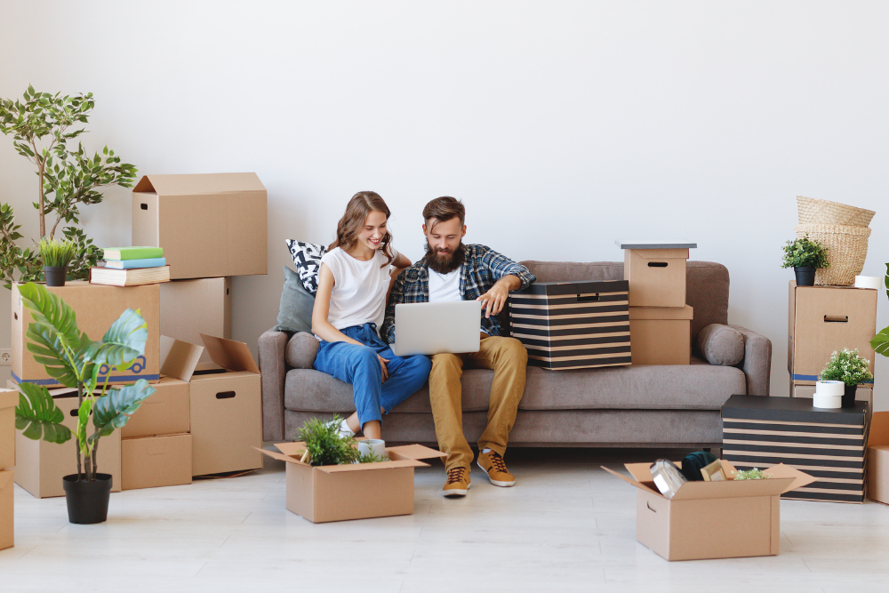 couple sat on a sofa as they move into a property