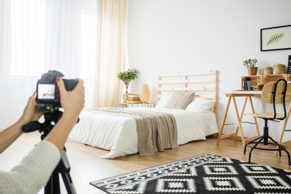 A woman taking picture of bedroom