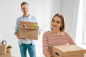 A picture of a woman and man holding a boxes