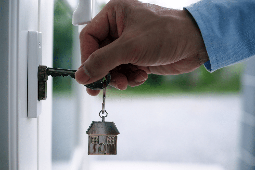 person putting a key in a door with a house keyring, OpenRent